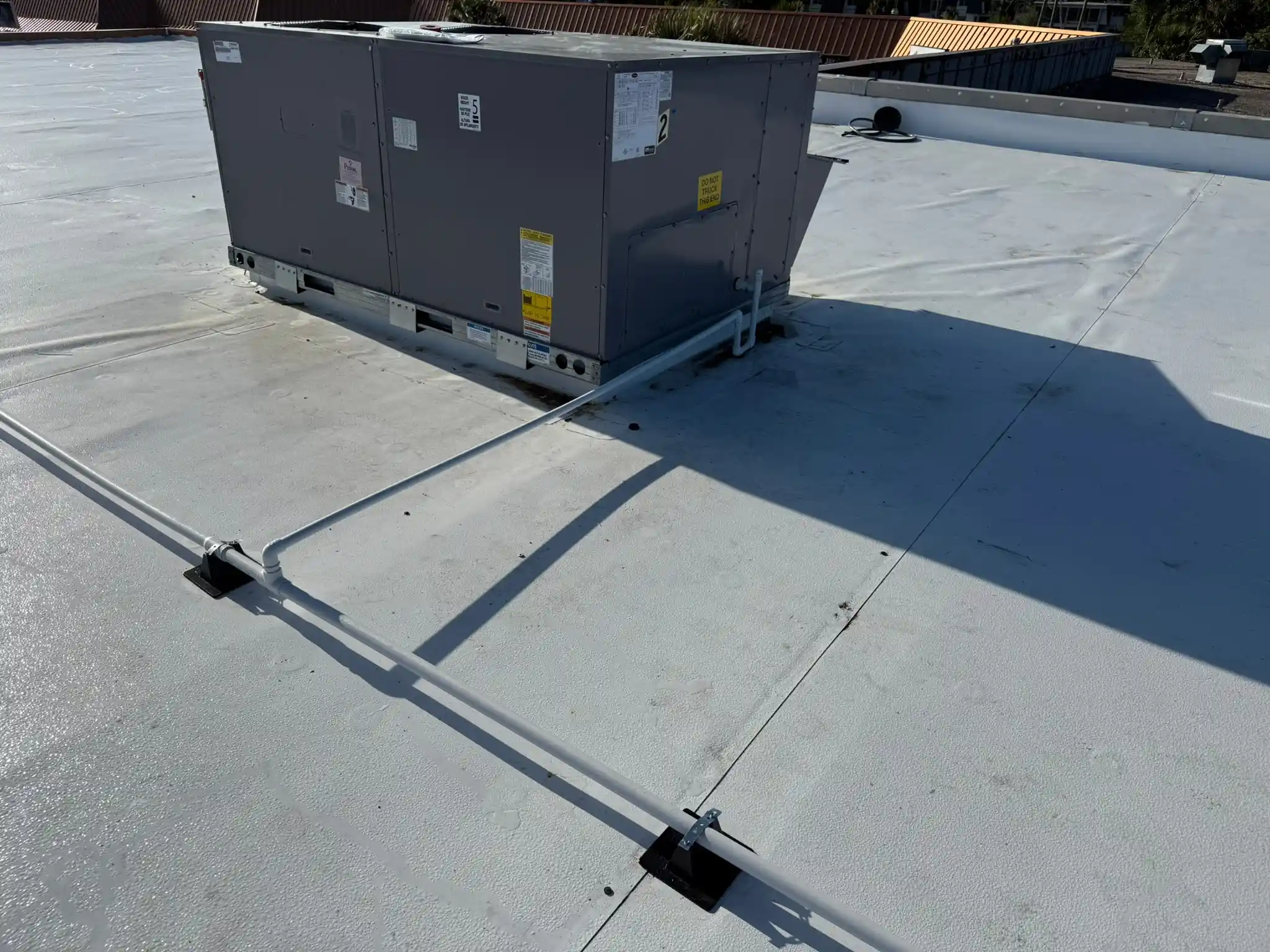 Carrier HVAC rooftop unit with ductwork and electrical connections on a commercial flat roof in St. Petersburg, FL.
