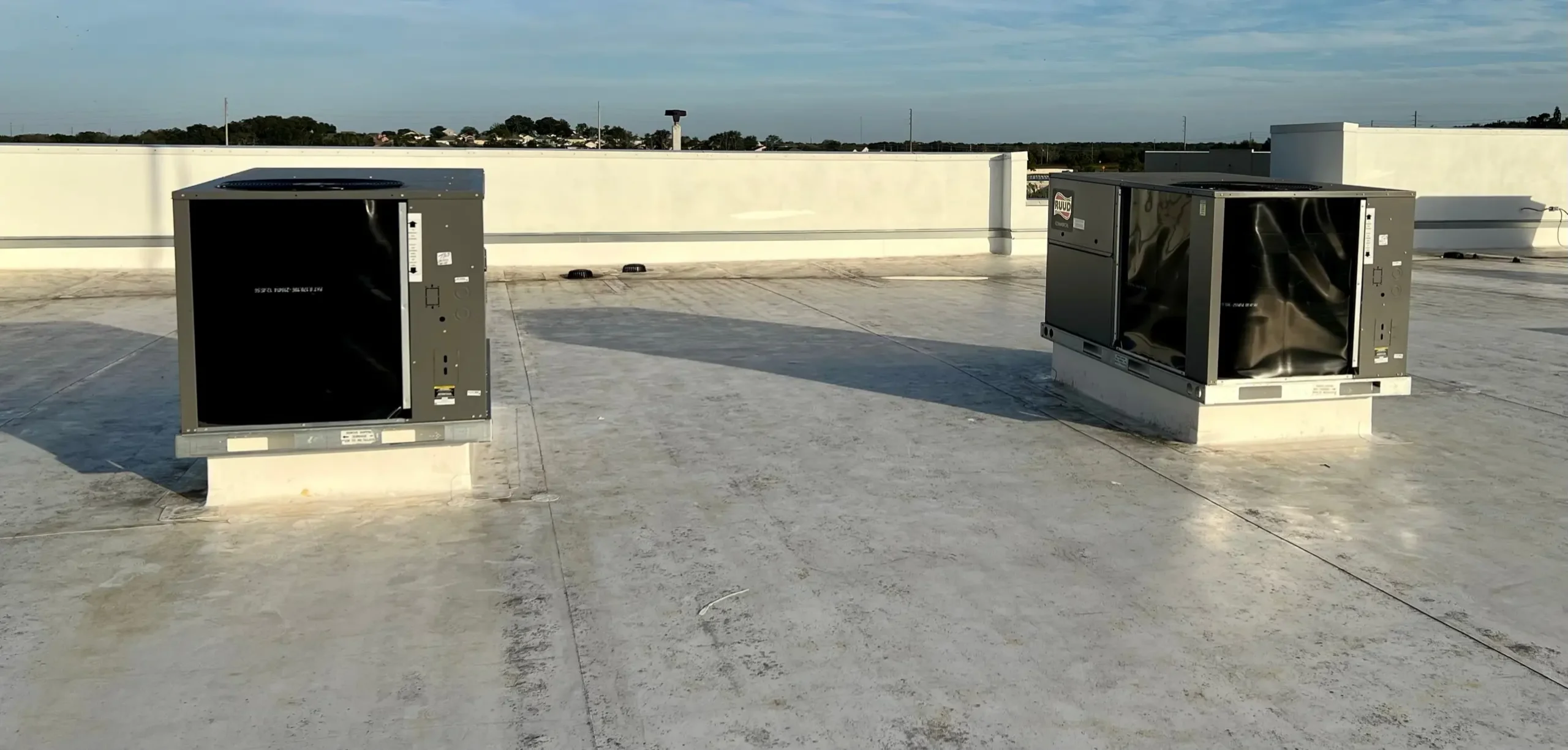 Commercial HVAC rooftop units installed on a building's flat roof, providing reliable heating and cooling for a business property.