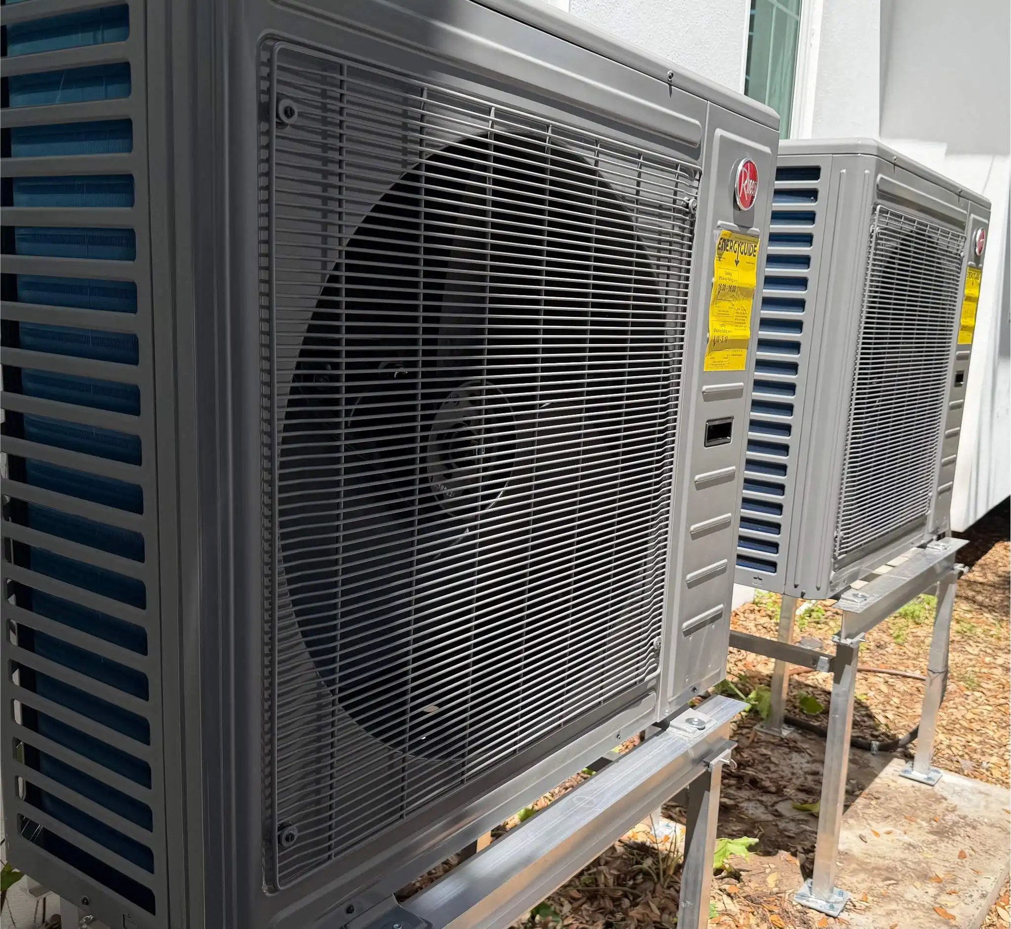 Newly installed outdoor HVAC condenser units for residential air conditioning system providing efficient cooling performance
