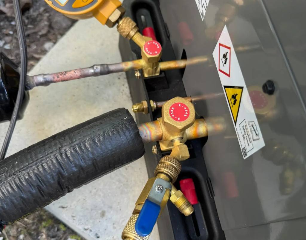 HVAC technician performing refrigerant pressure check using a digital gauge on a unit, ensuring optimal performance and cooling efficiency.