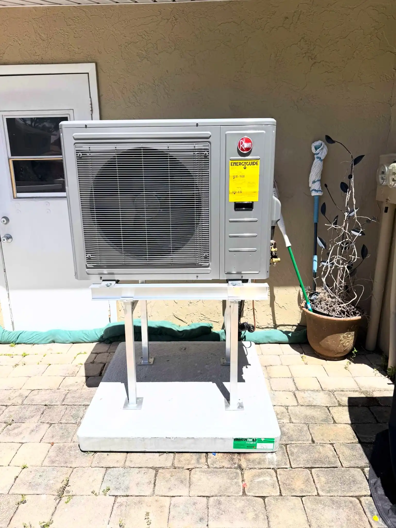 Rheem HVAC outdoor unit installed on a concrete base for residential air conditioning in St. Petersburg, FL.