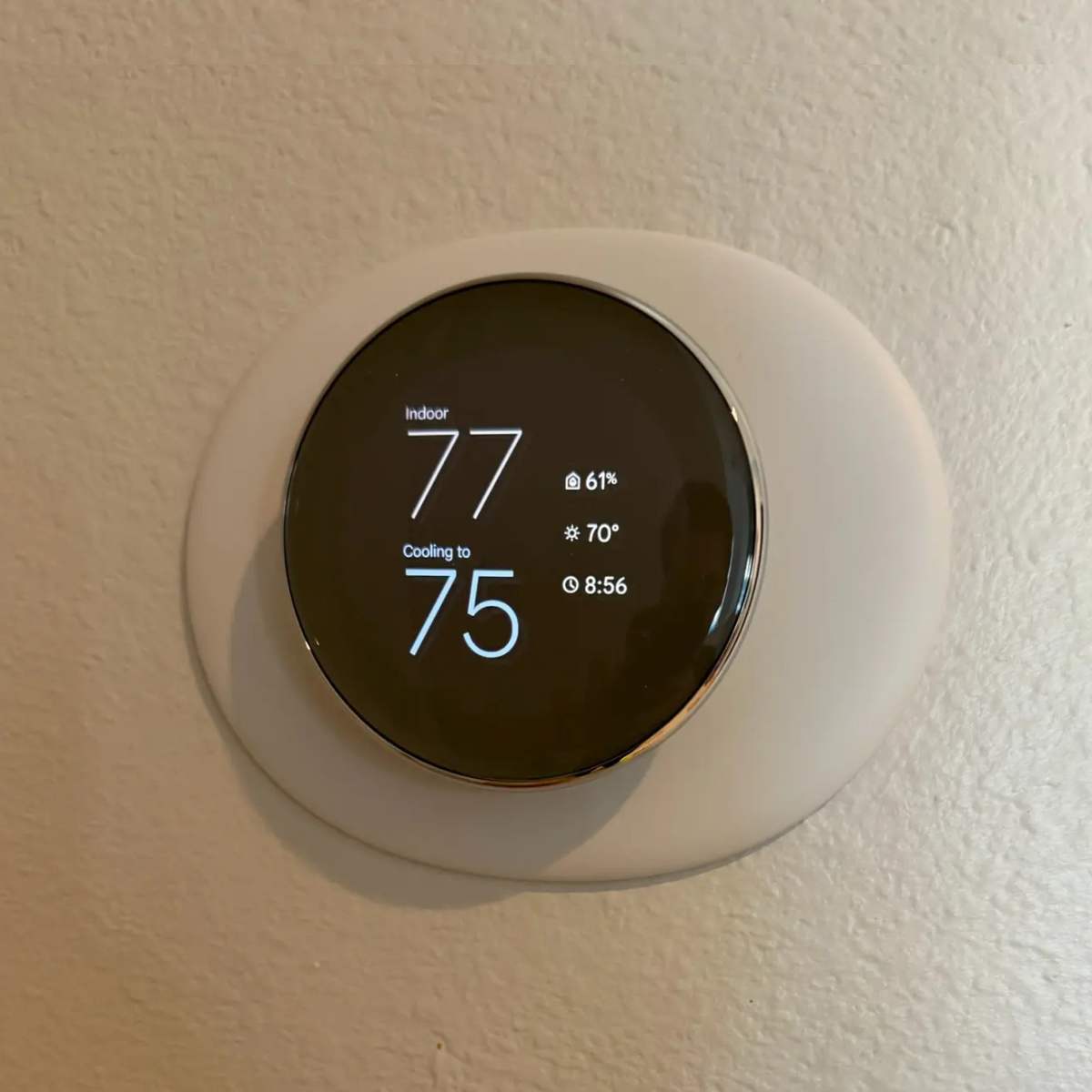 Smart thermostat displaying indoor temperature and humidity settings for energy-efficient air conditioning control.